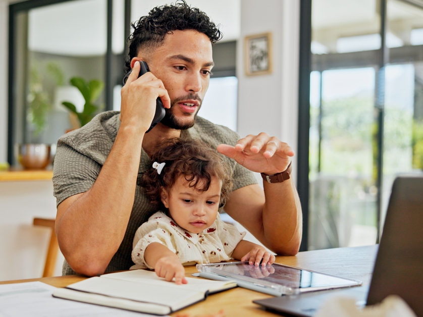 Talking dad holding baby on phone call and laptop for work stock photo