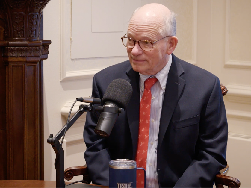 man sitting at microphone in podcast setting